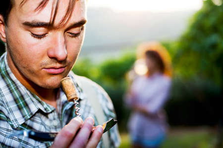 farmer sniffing wine cork to test the quality of the wineの写真素材