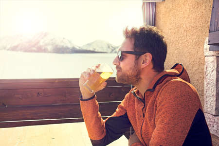 sitted and relaxed man drinking a beer in peaceの写真素材
