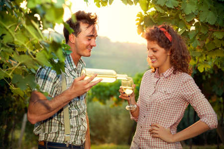 farming couple drinking a glass of wine after the harvestの写真素材
