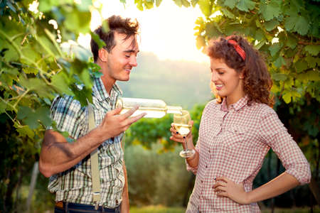 farming couple drinking a glass of wine after the harvestの写真素材