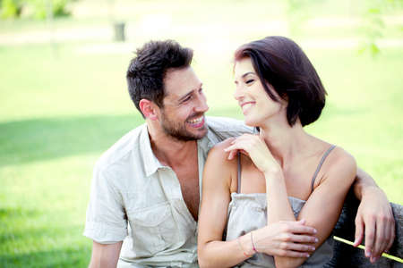 Couple in love seated together on a bench の写真素材