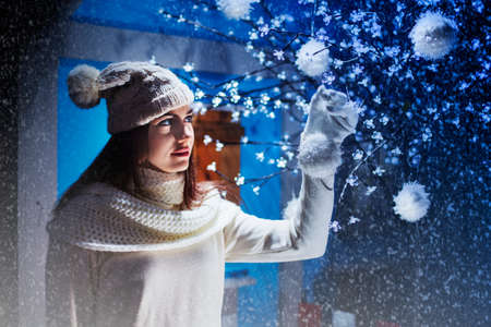 Girl puts decorations on the Christmas treeの写真素材