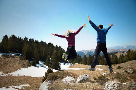 happy hikers jumping on the top of mountainの写真素材