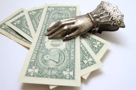 Dollars in a clothespin-holder, against a light backgroundの写真素材