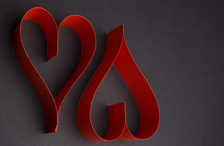 Valentine's Day two red hearts on dark background vertical