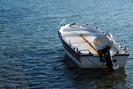 An old white fishing boat docked in the seaの写真素材