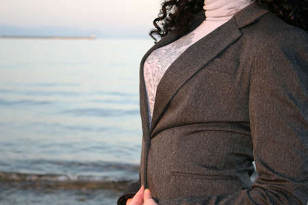 Woman at the beach shown only her chest wearing a jacketの写真素材
