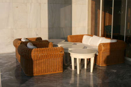 Outside bamboo sofa and tables lit by the sunの写真素材