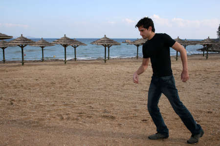 A handsome man walking at the beachの写真素材