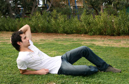 A handsome young man lying on the grass