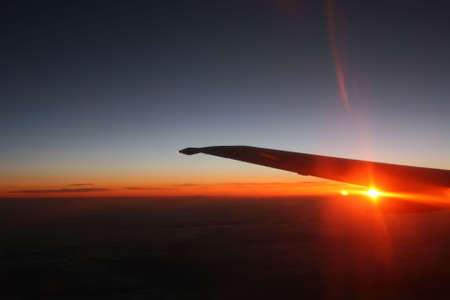 Sunset view from the aircraft window while flyingの写真素材
