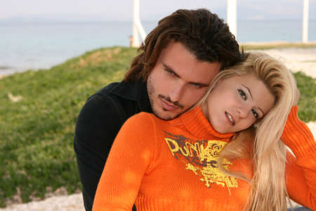 Young blonde couple hugging each other outdoorsの写真素材