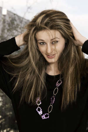 Beautiful young woman smiling and holding her hair
