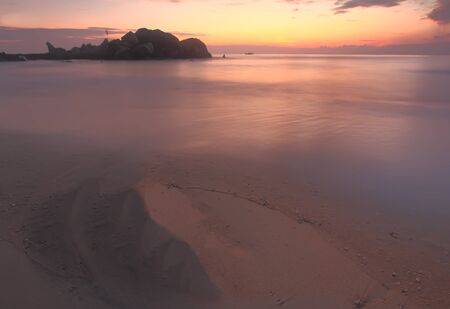 Seascape sunrise with rocks foreground at Penunjuk Beach, Kemaman Malaysia.Slow Mantion.Long Exposure.Soft Focus.の写真素材