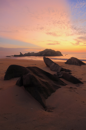 Photographer capturing the beautiful scenery in Pantai Penunjuk, Kijal, Terengganu with ray of light from sunriseの写真素材