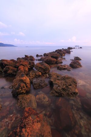 Glacial boulders, rocks and gravel in curving line at water's edge,の写真素材