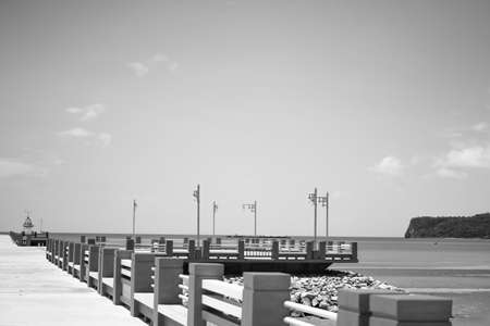The bridge extends to the sea with blue sky as black and white.の写真素材