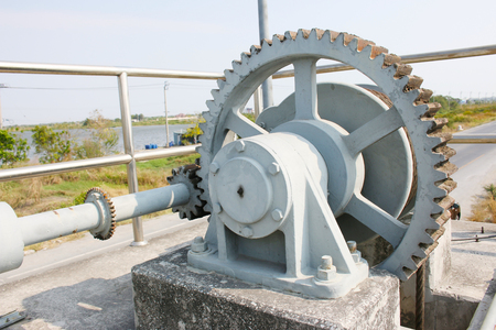 Machine is rusty cogs of the floodgates in rural areas, with asphalt roadsの写真素材