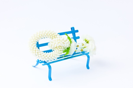 Jasmine garland on small blue chair in white background.の写真素材
