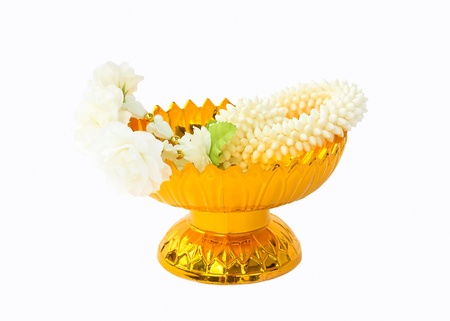 Jasmine garland on gold tray with pedestal, white background.の写真素材