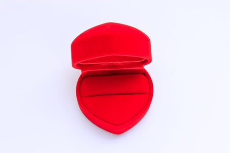 A heart-shaped ring box covered with velvet on white backgroundの写真素材