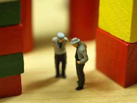 two litle old man figures chatting (selective focus on first figure)