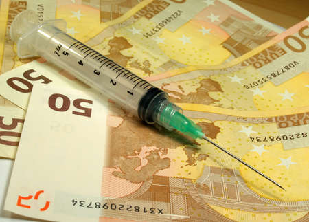 syringe over fifty euro banknotes   の写真素材