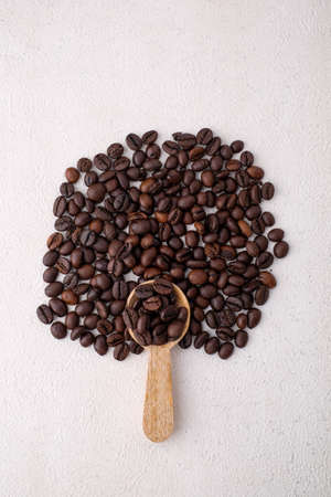 Wooden spoon filled with coffee beansの写真素材