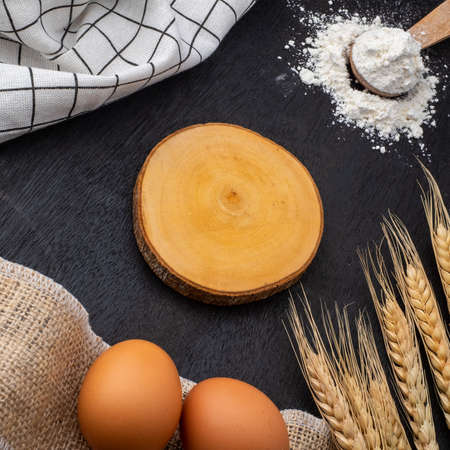 wheat ears, eggs and flour on dark board, top viewの写真素材