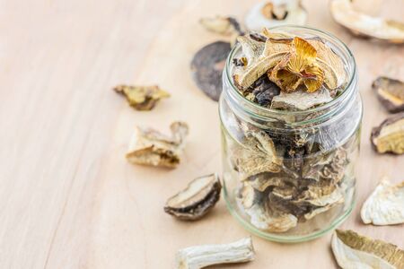 Dried porcini mushrooms in a storage jar on wooden background. Horizontal orientation-Imageの写真素材