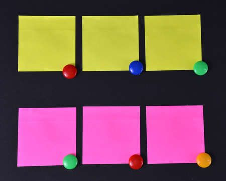 Yellow and pink stickers on black.