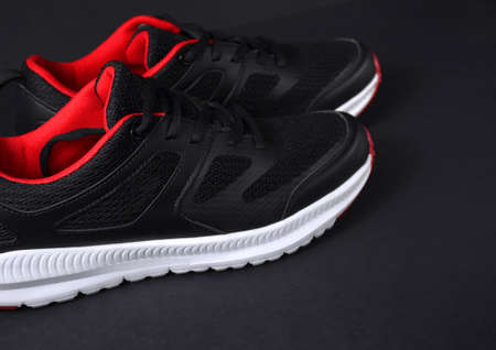 Black sneakers with red accents on a black background.の写真素材