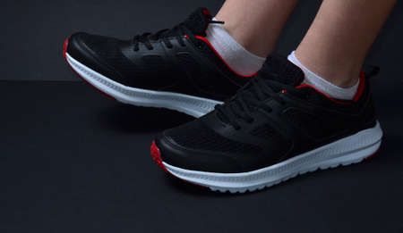 A pair of sneakers on the girl's feet.