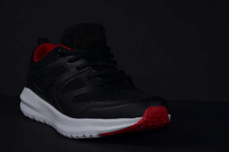 Black sneakers with red accents.