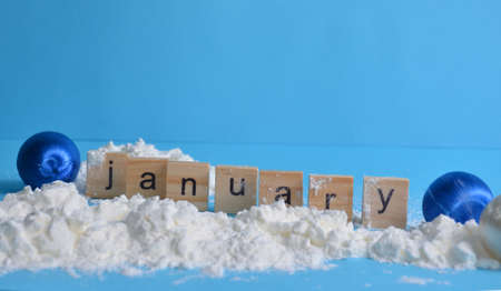 Snow Christmas toys on a blue background. The month of January is written in wooden letters. The calendar.の写真素材