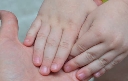 Baby's hands in mom's palm.の写真素材