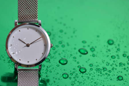 Women's watch on a green table.の写真素材