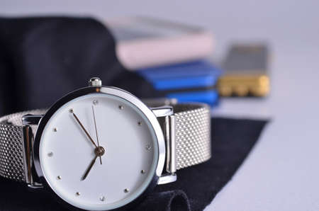 Women's watch, phone, flash drive and notepad on a white background.