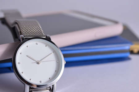 Women's watch, phone and notepad on a white background.の写真素材
