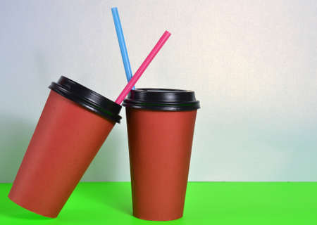 Two large red cups with straws.