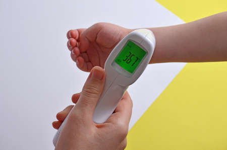 Measurement of body temperature with a non-contact thermometer.