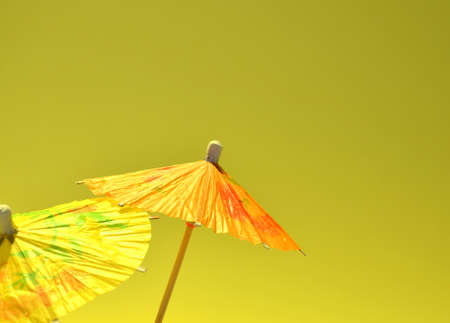 Yellow and orange umbrella on a gray-yellow background.の写真素材