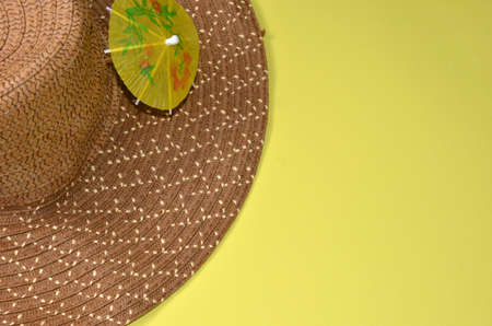 Brown hat and umbrella on a yellow background.の写真素材