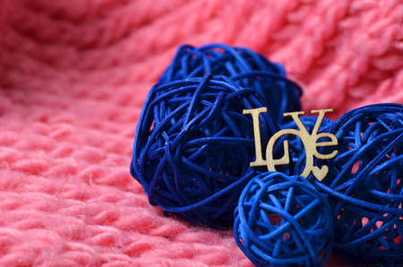 Blue decorative balls on a pink knitted scarf. love plate. Valentines Day