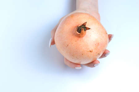 Pomegranate fruit in hands on a gray background.の写真素材