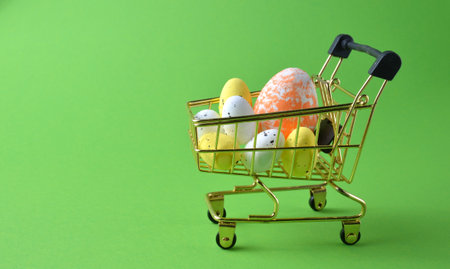 Easter eggs in a shopping basket on a green background. Easter.の写真素材