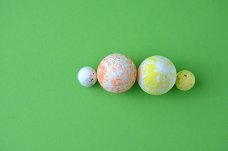 Easter eggs of different sizes. View from above. Green background.