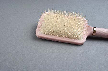 Pink hair comb close-up on a gray background