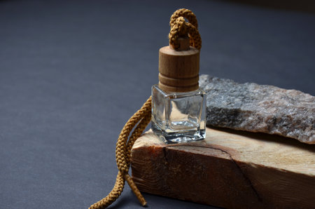 Perfume and gray stone on a tree. Black background.の写真素材