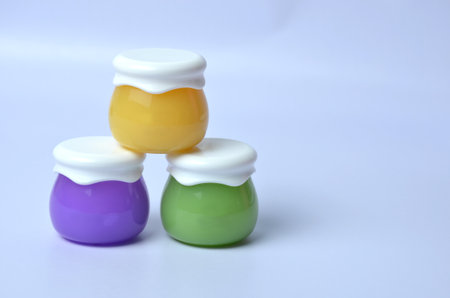 Three jars for cream on a blue background.